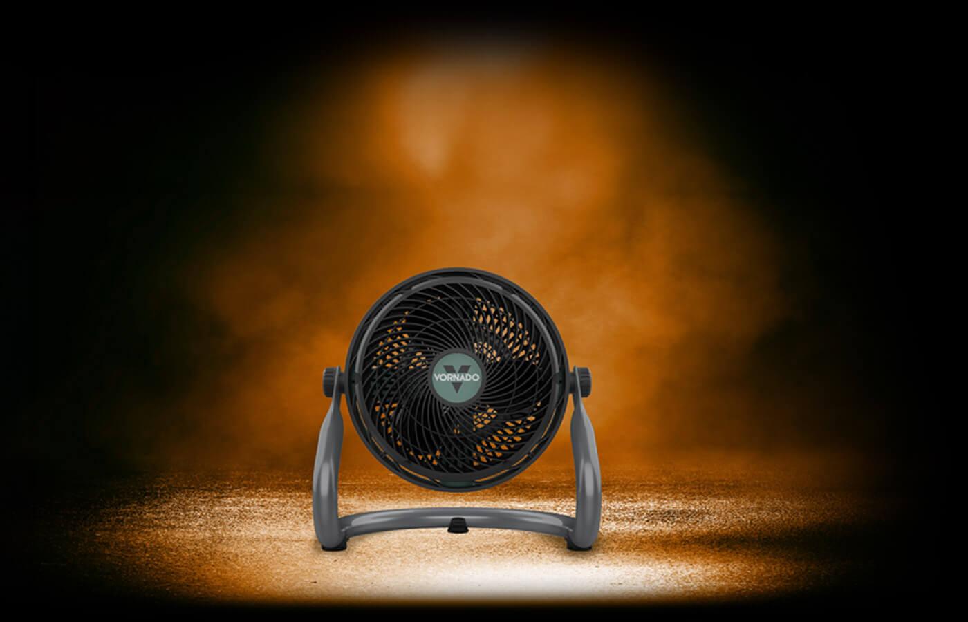 EXO61 HD IP54 Motor EXO61 HD on dark asphalt. The fan is under an orange light with orange smoke in the background surrounded by darkness
